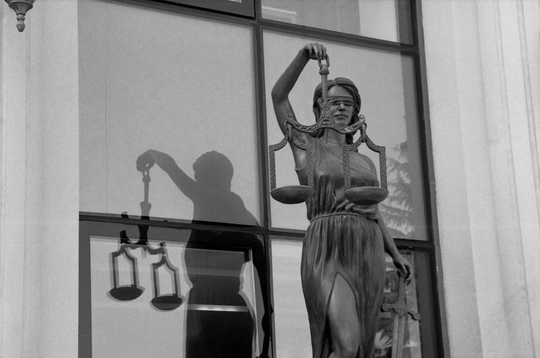 lady justice statue with reflection in window